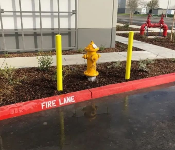 A fire hydrant in the middle of a parking lot.