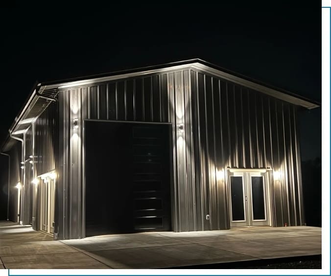 A large metal building with lights on the side.