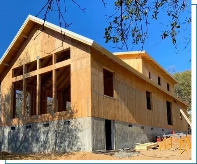 A building under construction with wood on the side.